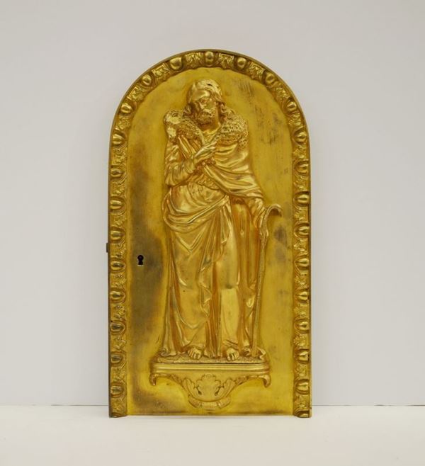 Anta di tabernacolo, sec. XIX, in bronzo dorato, raffigurante Cristo Buon   Pastore, alt. cm 21,5, entro cornice dorata decorata a ovuli e palmette