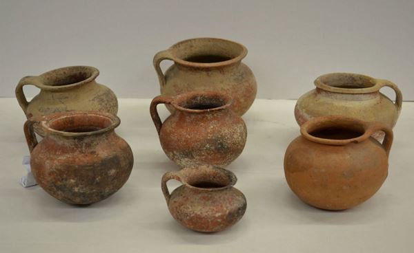 Sette brocche acrome. Materia e tecnica: impasto rosato e arancio; modellate a tornio veloce. Orlo estroflesso, breve collo cilindrico a profilo concavo indistinto, corpo globulare e globulare schiacciato, fondo piatto, ansa a nastro impostata verticalmente dall'orlo alla spalla (7) Produzione: ceramica daunia. Stato di conservazione: sei integre; una con lacune. Dimensioni: alt. da cm 13 a cm 7; diam. bocca da cm 13,5 a cm 7. Datazione: V-IV a.C.