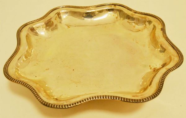 Vaschetta in argento con bordo sagomato a quattro piedini diam. cm 29, g 527