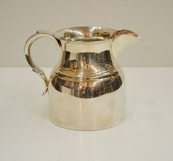 Brocca in metallo argentato con presa a voluta, alt. cm 17