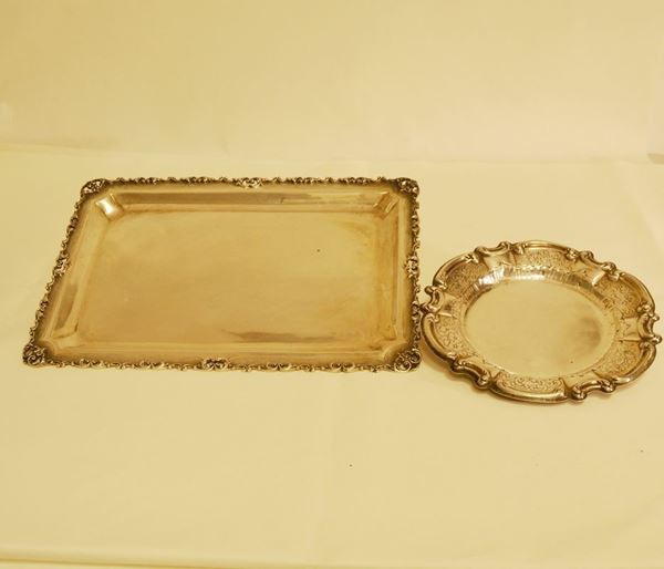 Vassoio di forma rettangolare in argento con bordo lavorato e traforato cm 25x25 e piattino di forma rotonda in argento cesellato, diam. cm 22 totale, g 1070 (2)