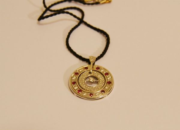 Pendente in oro bianco decorato da rubini e paveâ€™ di brillantini  appeso a un cordonetto nero