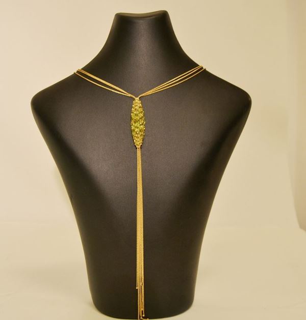 Collana, a tre maglie fini in oro con elemento rigido in oro decorato da Peridoti e fili di oro pendenti, g 32,3