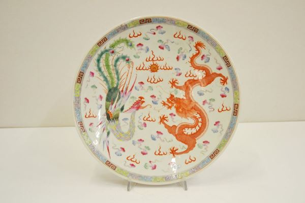 Piatto Cina sec. XX, in porcellana policroma, decorato con una fenice e un  drago, diam. cm 38