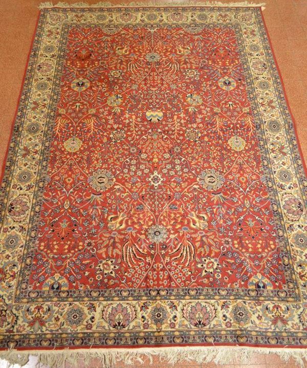 Tappeto Isfahan, sec. XX, fondo rosso a motivi floreali, bordura avorio, cm 350x254