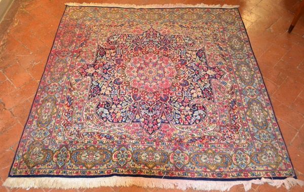 Tappeto orientale, fondo blu, decori floreali nei toni del rosso e azzurro, cm 197x192, stinto