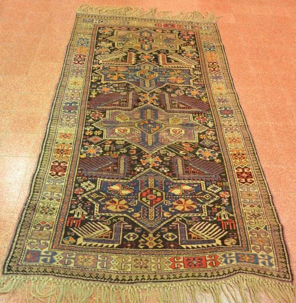 Tappeto orientale fondo scuro con decoro a losanghe, cm 145x245, consunto