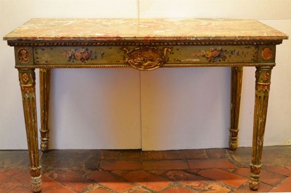 Console, fine sec. XVIII, in legno intagliato e dipinto nei toni del verde, piano rettangolare in breccia di marmo rosa, fascia dipinta con motivi      floreali e centrata da medaglione con figura femminile distesa, mentre ai   lati sono presenti clipei con profili di imperatori, gambe  scannellate     desinenti in ciuffo di foglie di acanto su piedi a cipolla, cm 135,5x66x86, danni e mancanze