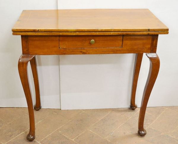 Tavolino da gioco, Toscana, fine sec. XVIII, in noce filettato, piano da    aprirsi a libro, intarsiato nella parte interna con riserva sagomata e      scacchiera, un cassetto nella fascia, alte gambe sinuose su piedi a zoccolo stilizzato, chiuso cm 82x41x76