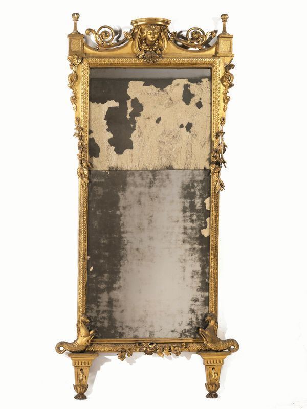 Specchiera, Toscana, sec. XVIII, in legno intagliato e dorato, cimasa       centrata da mascherone femminile con collana di sfere inquadrata da volute  da cui partono girali vegetali, cornice di forma rettangolare decorata a    intreccio, motivi fitomorfi e floreali, base centrata da fiocco e ai lati   due cavalli marini che si affrontano, cm 213x95, danni