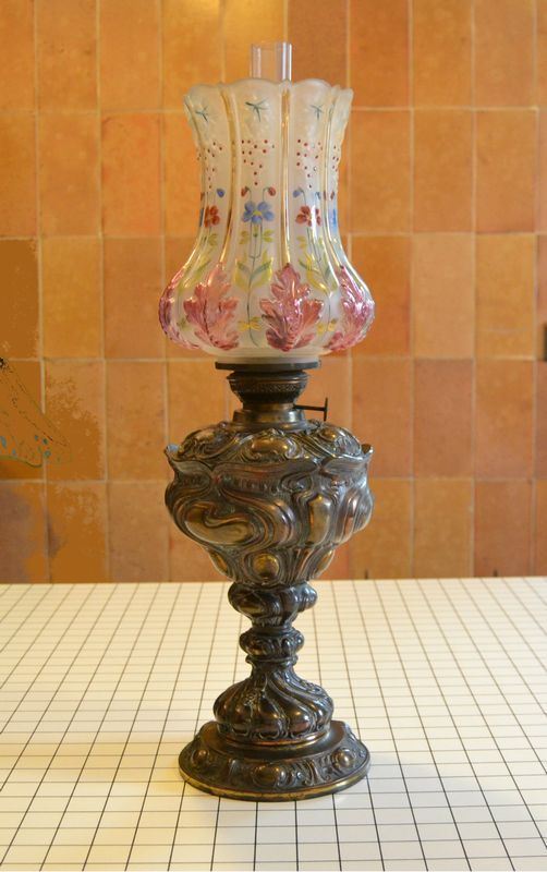 Lume a petrolio Liberty, primi sec. XX, in metallo lavorato, campana in vetro decorata, alt. cm 60