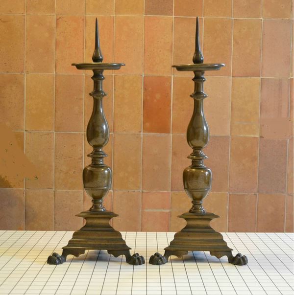 Coppia di candelieri, Toscana, sec, XVII, in bronzo,fusto con stemma nobiliare, base triangolare, piedi felini, alt. cm 60 ( 2 )