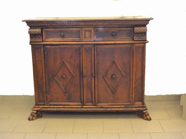 Credenza, Lombardia, sec. XVIII, in noce intagliato, due sportelli sformellati, due cassetti, piedi felini, cm 132x53x109, parti ricostruite con materiale antico
