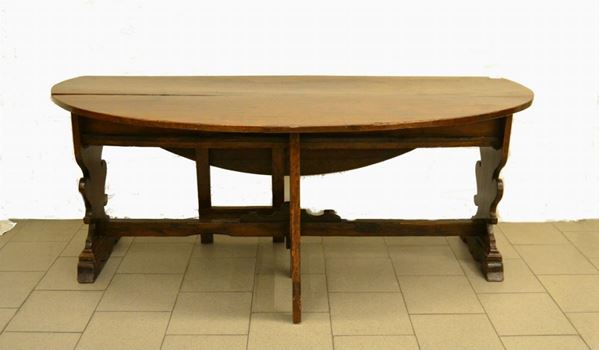 Tavolo, Umbria, sec. XVII, in noce, piano con alette ribaltabili, gambe ad asso di coppe riunite con traverse, due cassetti, cm 195x129x79, restauri