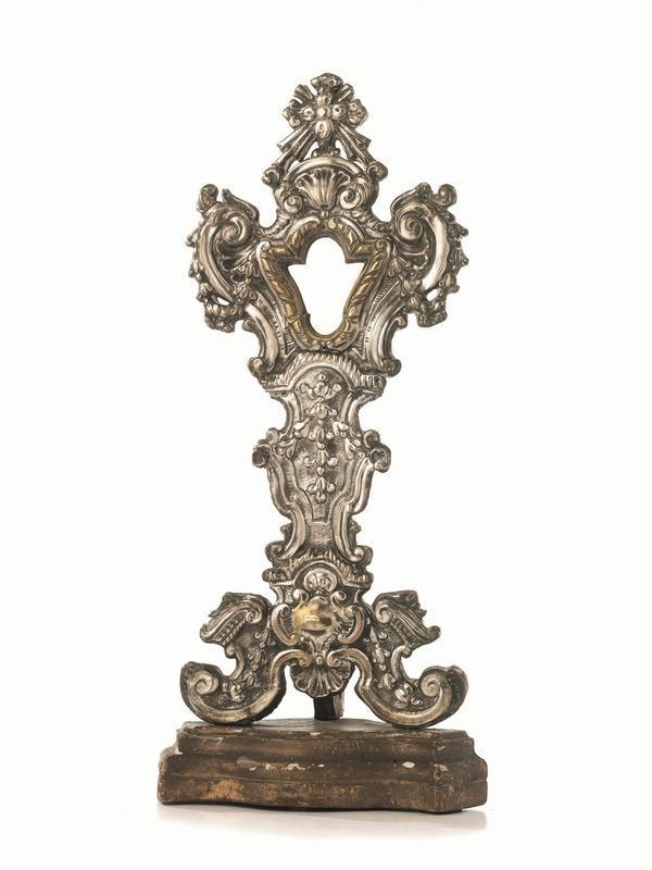  Ostensorio, Italia centrale, sec. XVIII,  in lamina di metallo argentato e sbalzato a volute e festoni di fiori, applicata su sostegno in legno, alt. cm 53,5,  presenta modifiche e piccoli danni  
