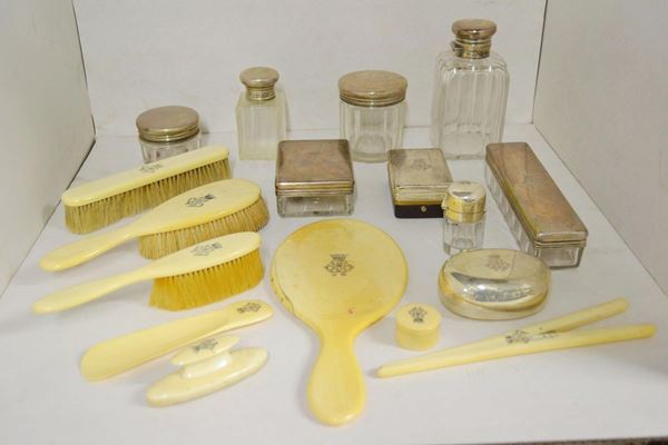 Grande servito da toilette, Londra, 1891,  composto di quattordici flaconi con tappi in argento, cinque spazzole ed uno specchio a mano in avorio; undici accessori in avorio e metallo argentato; il tutto entro grande scatola in pelle,  molto danneggiata 