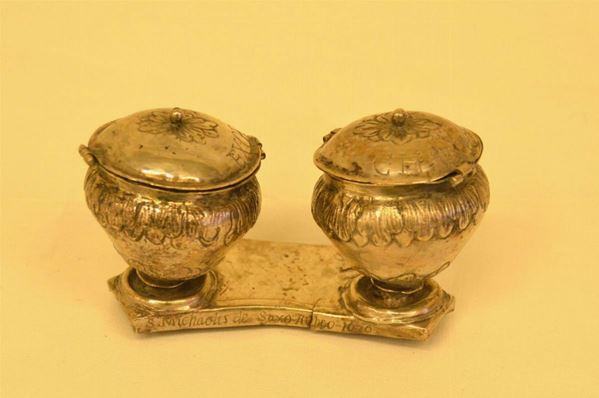 Due vasetti per olio santo in argento sbalzato e cesellato con foglie,base sagomata con iscrizione e data 1676 cm 11x7 (difetti
