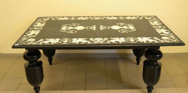 Tavolo con piano in lavagna con intarsi in marmo a figure di leoni alati  e anfore con base in legno laccato nero 182x112x76