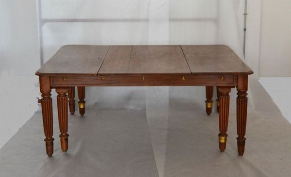  Grande tavolo da pranzo, inizi sec. XX, in noce, piano allungabile, quattro gambe scanalate, rapporti in metallo dorato, cm 183x147x76, completo di tre prolunghe da cm 50 lÃ¢Â€Â™una, difetti                                                   