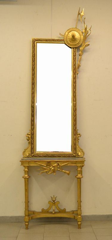  Console e specchiera, Toscana, sec. XX, in legno dorato e intagliato a strumenti musicali, maschere e lance, piano in marmo, cm 85x29x287                                                                            