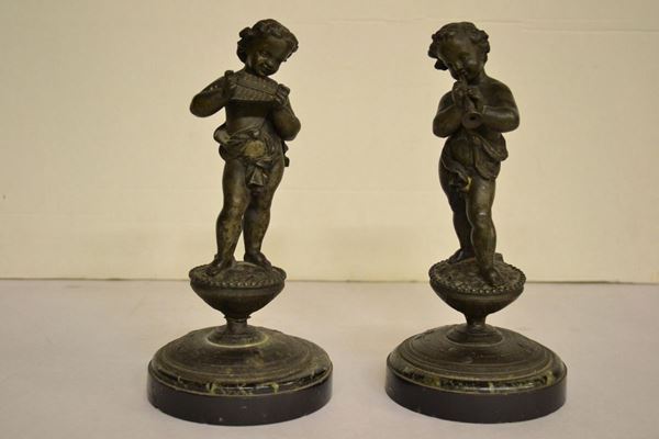  Due bronzetti,  raffiguranti putti suonatori su basi in marmo nero,  danni 