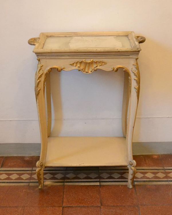  Tavolino, inizi sec. XX, in legno laccato bianco-oro, a due ripiani, cm 62x39x80 