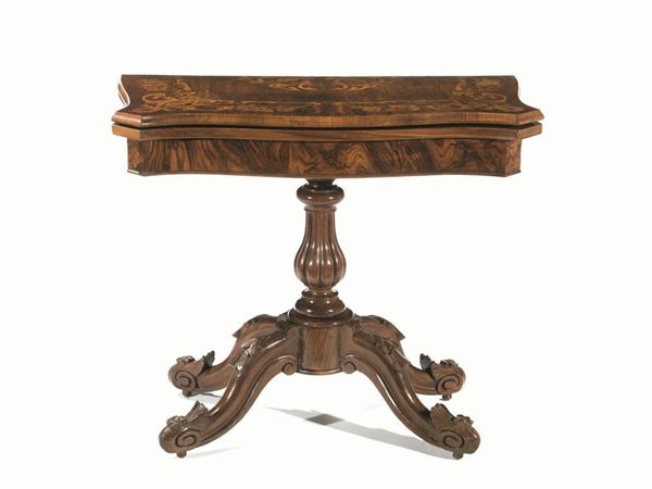  Tavolino da gioco, fine sec. XIX,  in noce e palissandro riccamente intarsiato a motivi floreali, piano sagomato da aprirsi a libro, fusto tornito a balaustro scannellato su quattro gambe a voluta decorate a motivi floreali in rilievo, piedi a rotelle in bronzo, chiuso cm 88x44x78