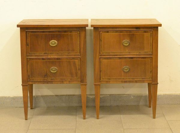  Coppia di comodini, in stile Luigi XVI, in noce filettato a due cassetti, gambe troncopiramidali, cm 45x30x65 