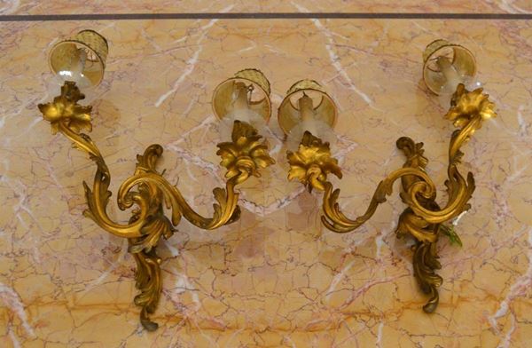  Coppia di appliques, in stile settecento, in bronzo dorato modellate a      