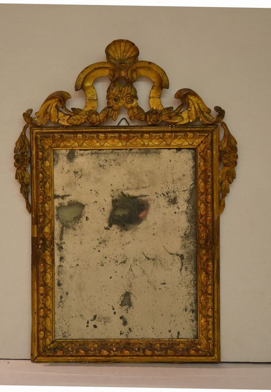  Piccola specchiera,  in legno intagliato e dorato, di forma rettangolare, cimasa traforata a volute e festoni di fiori ricadenti ai lati, cornice decorata da motivi a ovuli, cm 51x35,  ricostruita con materiale antico, danni e cadute alla doratura 