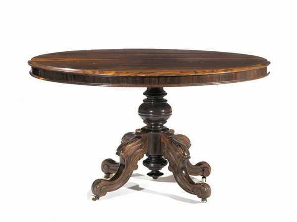  Tavolo, Inghilterra, fine sec. XIX,  in palissandro, piano ovale apribile a vela, fusto tornito a balaustro su quattro gambe a voluta con piedi a rotelle, cm 124x92x77,  alcuni restauri 
