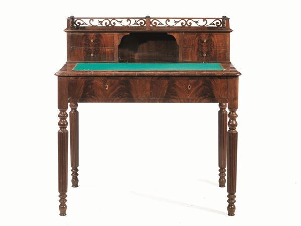  Scrivania da centro, Livorno, seconda metÃ  sec. XIX,  in piuma di mogano, piccolo scarabattolo con terrazzino superiore traforato a volute, a quattro cassetti e vano centrale, piano in velluto verde, due cassetti nella fascia, gambe tornite e scannellate, cm 104x71x110