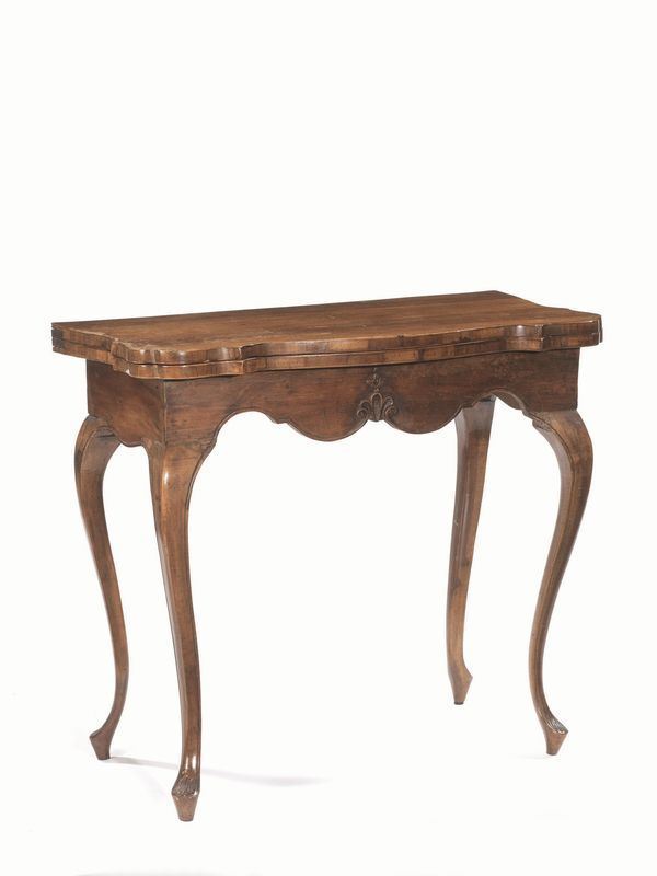  Tavolino da gioco, Veneto, sec. XVIII,  in noce,   piano sagomato da aprirsi a libro, pendaglina  frontale centrata da motivo a palmetta, alte gambe sinuose su piedi a ricciolo stilizzato, chiuso cm 82x44x74