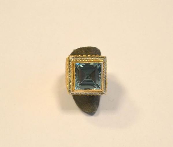 Anello in oro giallo e bianco, titolo 375, con topazio azzurro e brillanti, g 15,7