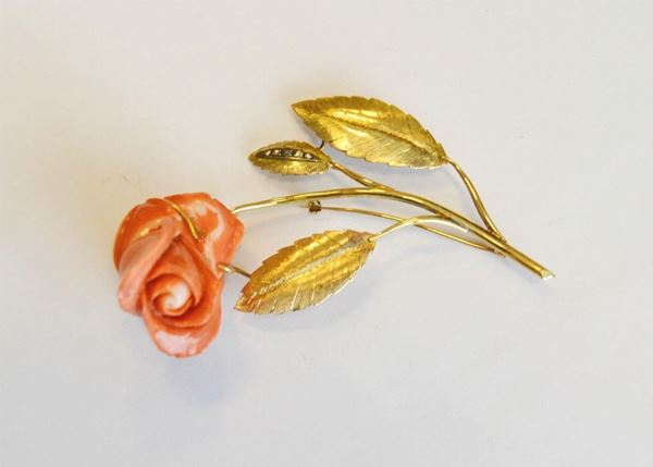 Grande spilla in oro giallo, corallo e diamanti modellata a rosa in corallo con gambo e foglie in oro cesellato impreziosita da rose di diamanti,  g 34                                    