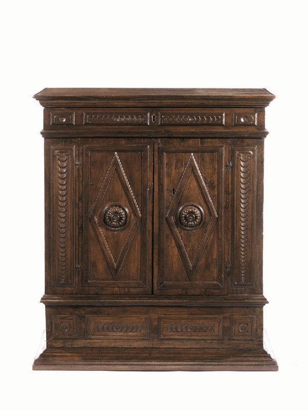 Credenzino, Italia centrale, sec. XVII, in noce a patina scura, piano rettangolare, un cassetto sotto al piano con formelle decorate a rosette, due sportelli sottostanti con lesene e cornici in rilievo, inquadrate da lesene stilizzate, base modanata, cm 88x45x101, presenta restauri e trasformazion