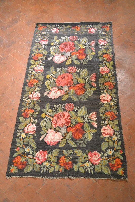  Tappeto russo,  fondo nero decorato a fiori policromi, cm 300x160,  consunzioni e danni 