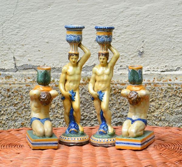 Quattro candelieri, sec. XIX, in maiolica decorata con sostegni a figure ( 4 )