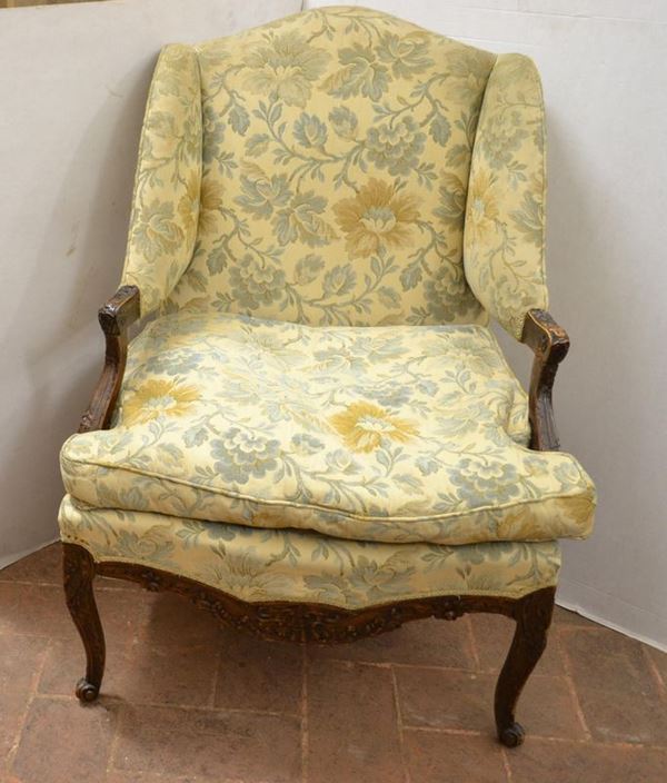  Poltrona a bergere, Piemonte, metÃ  sec. XVIII,  in noce intagliato a patina scura, spalliera sagomata, braccioli a giorno su sostegni mossi decorati a motivi fitomorfi, pendaglina sagomata frontale e laterale, gambe mosse su piedi a ricciolo, ricoperto di cotone operato