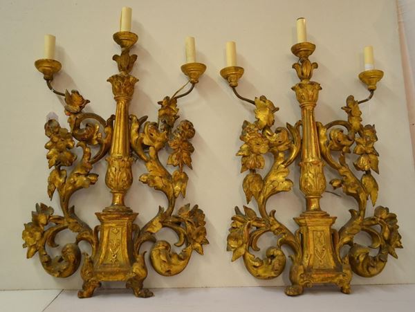  Coppia di grandi appliques , a tre luci con parte centrale a balaustro scannellato affiancato da grandi volute floreali, piedi in forma leonina, alt. cm 88,  costruite con materiale antico 