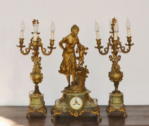 Trittico, Francia, sec. XX, composto da orologio in onice e metallo dorato con figura femminile, e coppia di candelieri a quattro luci, alt. cm 75 ( 3 )
