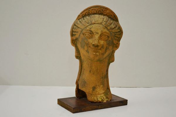  Testa femminile votiva  di gusto archeologico, in terracotta, alt. cm 29,  una lacuna sul naso 