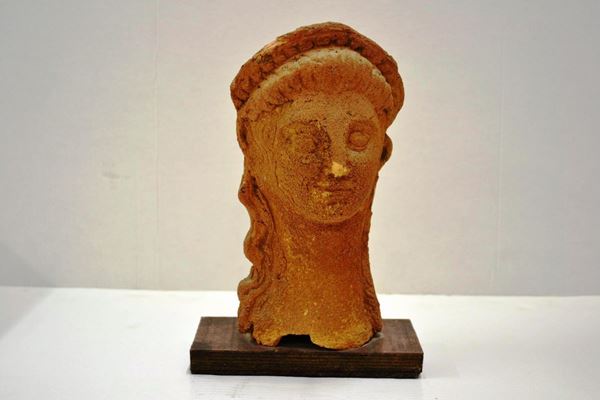  Testa femminile votiva  di gusto archeologico, in terracotta, alt. cm 29,  lacuna sul collo 