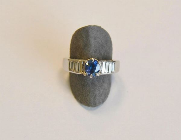        Anello in oro bianco, zaffiro e diamanti,  con zaffiro ovale montato a griffe e diamanti di  taglio carrÃ¨ affiancati, e brillanti laterali, g 9,7                                                                     
