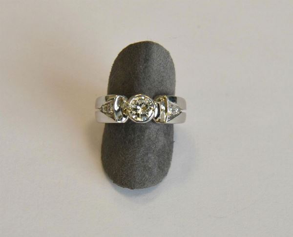        Anello in oro bianco e diamante ,  al centro brillante di ct  0,70 e 4 brillantini laterali , g 7,2                        