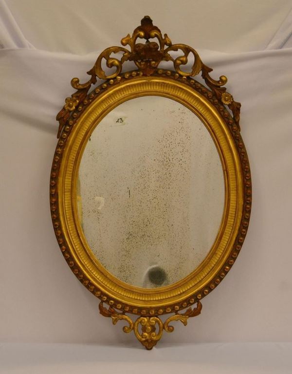  Specchiera, sec. XIX,  in cornice ovale dorata e 