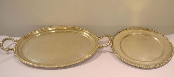  Due vassoi,  in argento rispettivamente di forma ovale a due manici , bordi a cordonetto, cm 55X32 e di forma circolare, diam. cm 32 , totale g 1890 (2)