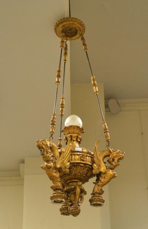 Lampadario, sec. XX, in legno dorato e intagliato con figure alate, a sette luci, cm 130x5