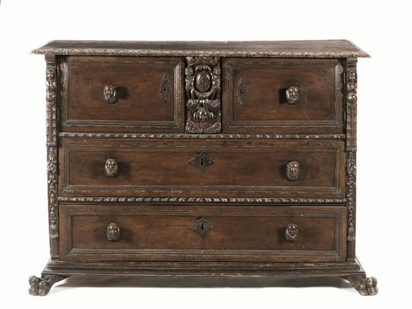  Cassettone a bambocci, Liguria, metÃ  sec. XVII,  in noce scolpito a patina scura, piano rettangolare con bordo scolpito a rosette, due sportelli e un cassetto con prese scolpite a cariatidi sotto la fascia ed altri due cassetti sottostanti con cornici baccellate e a fuseruole, inquadrati tra telamoni femminili, base modanata, piedi a zampa ferina, cm 136x57x95,  danni e modifiche 