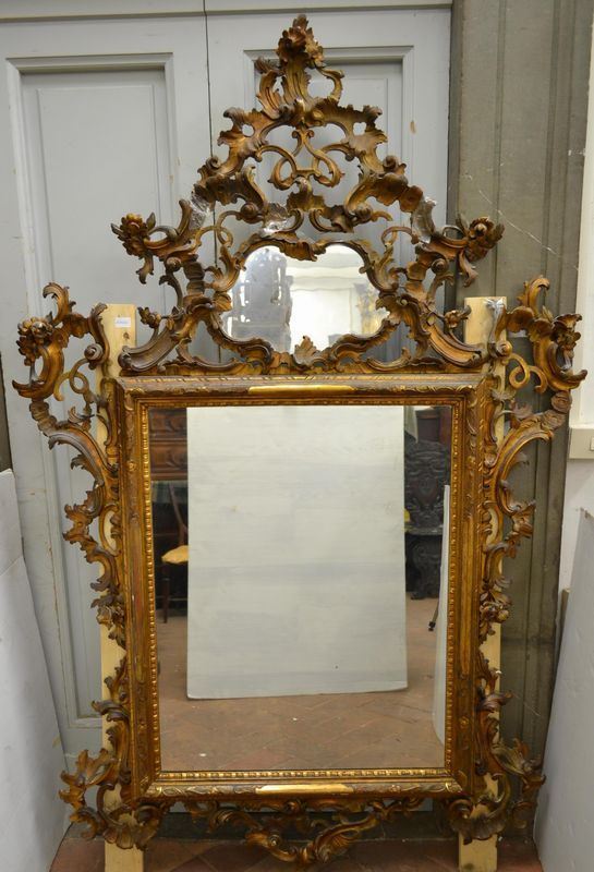   Specchiera, in legno intagliato e dorato , alta cimasa traforata centrata da specchio, ampi girali che ricadono sui lati della cornice, cm 220x140
